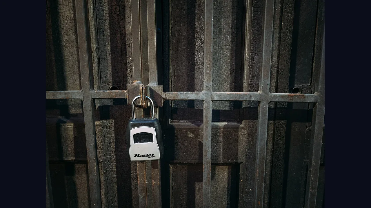 A padlock on a metal gate close up